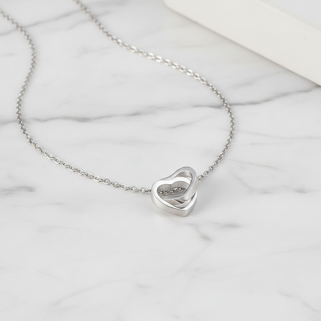 Entangled Hearts Pendant flat lay on marble